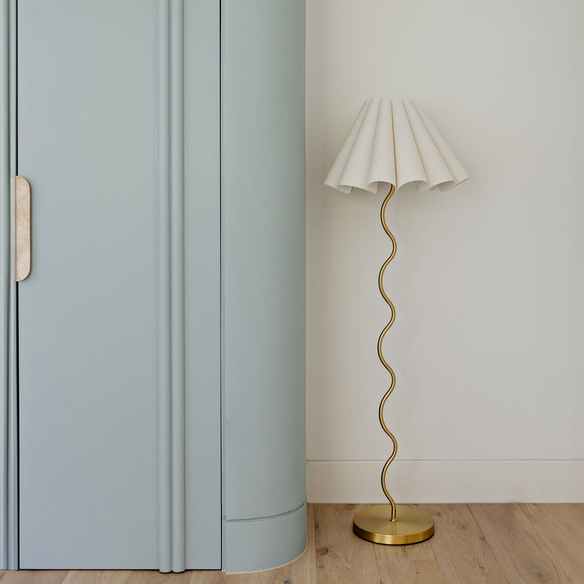 Cora Floor Lamp – three-quarter view of the brass squiggly stem and cream linen fluted shade by Paola And Joy