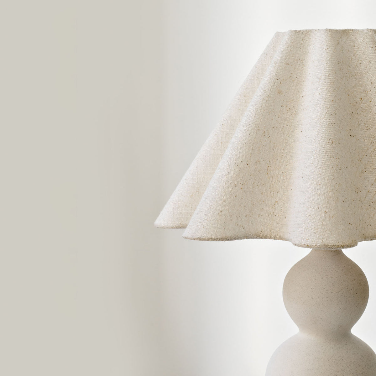 Mila Table Lamp – side profile of the curved cream ceramic base by Paola And Joy